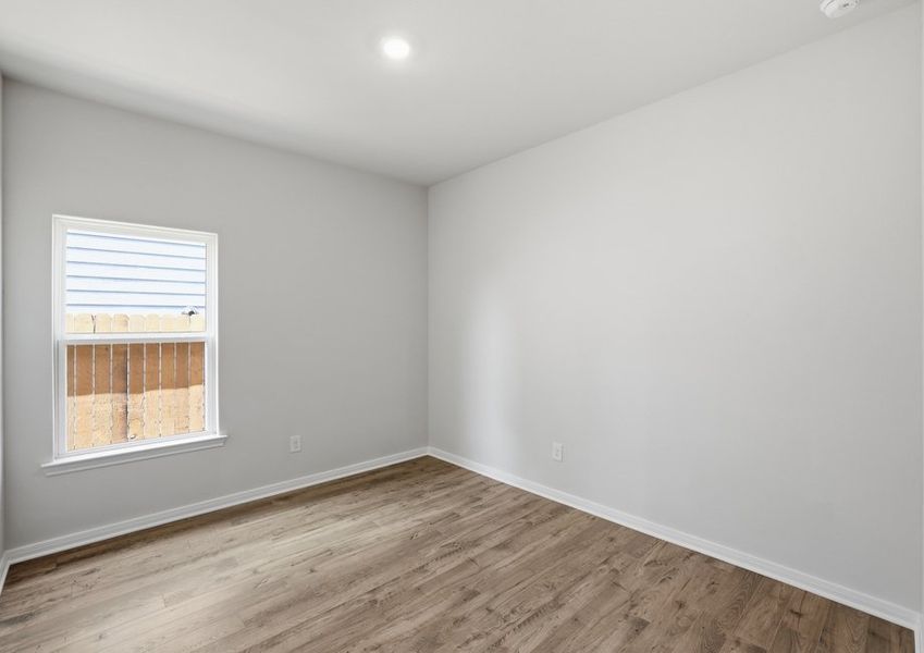 Primary bedroom featuring a window and wood-look flooring.