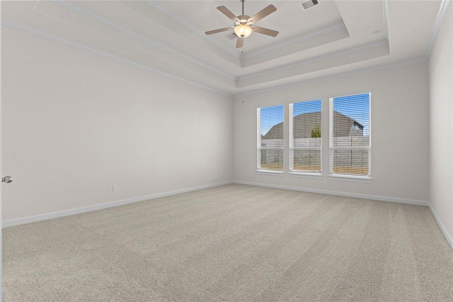 The spacious primary bedroom offers a peaceful retreat with plush carpeting, high ceilings, and an abundance of natural light, providing ample room for large furniture while maintaining a calm and comfortable atmosphere for everyday relaxation.