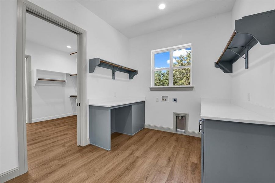 Laundry room featuring hookup for a washing machine, hookup for an electric dryer, and light hardwood / wood-style flooring