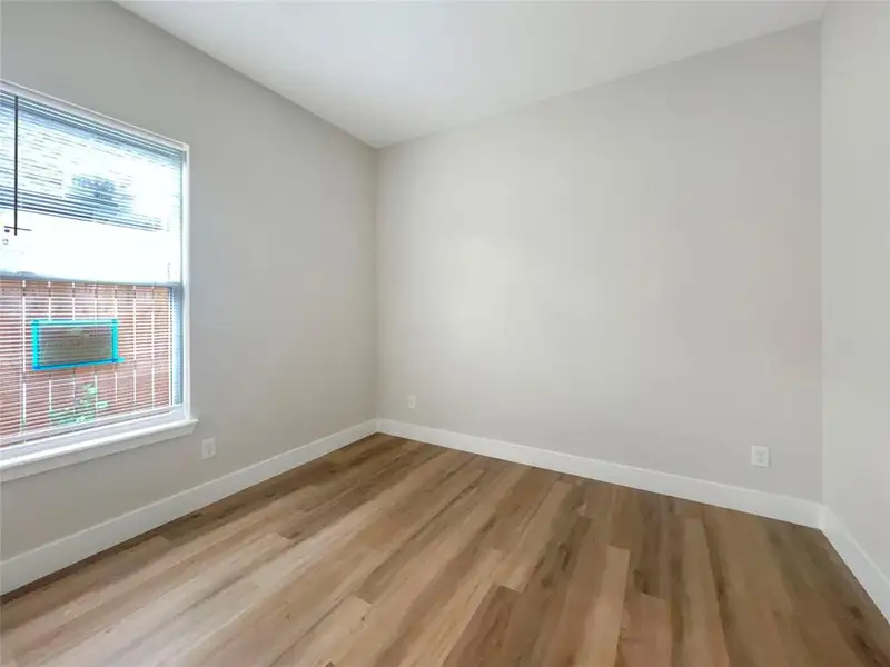 Unfurnished room featuring light wood finished floors and baseboards