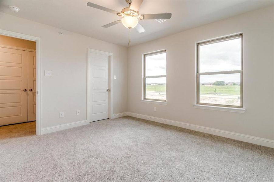 Spare room featuring light colored carpet and ceiling fan