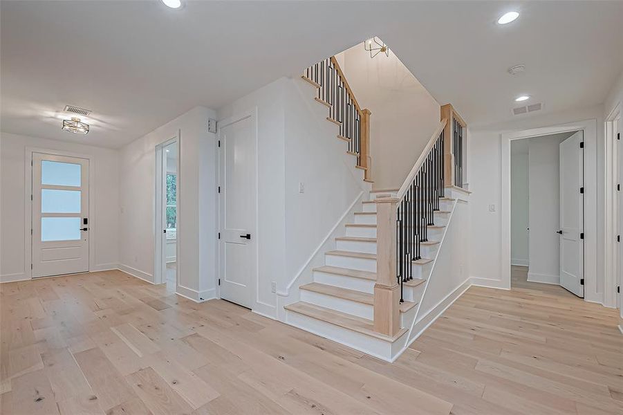 entryway with wood flooring, view of th study, staircase, closet, hallway to secondary bedroom and bathroom