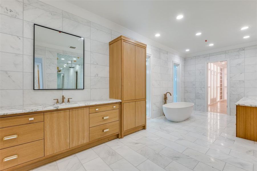 Bathroom featuring shower with separate bathtub, vanity, tile walls, and ornamental molding