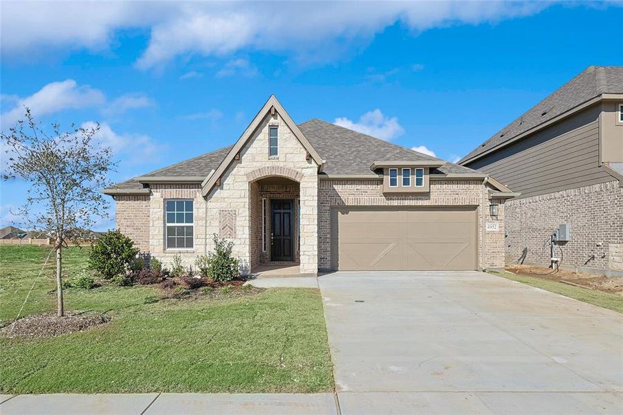 French country style house featuring a front yard and a garage