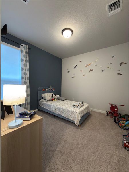 Plush carpet flooring complements a neutral color palette with an accent wall