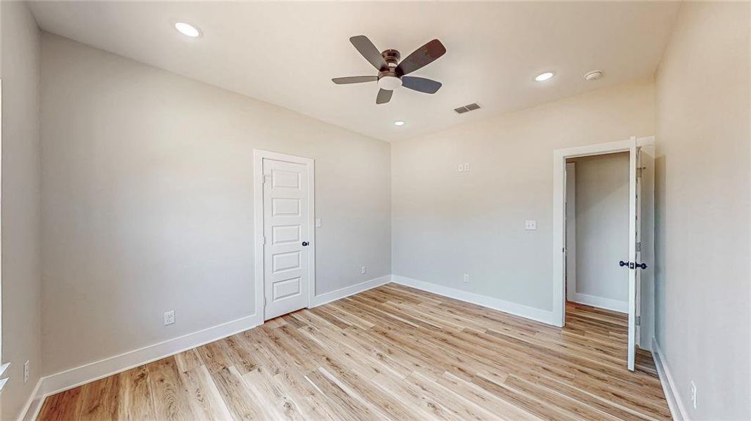 Empty room with a ceiling fan, light wood-style flooring, and recessed lighting Empty room with a ceiling fan, light wood-style flooring, and recessed lighting