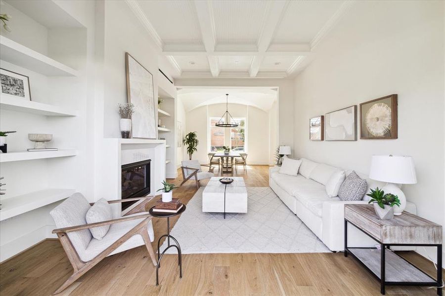 Open and Inviting - This Luxurious family room features a coffered ceiling, a brilliant fireplace flanked by shelving on both sides anchored by wide planked hardwood engineered floors. It exudes both warmth and sophistication Glass expanse doors open to the backyard seamlessly blending indoor outdoor living.