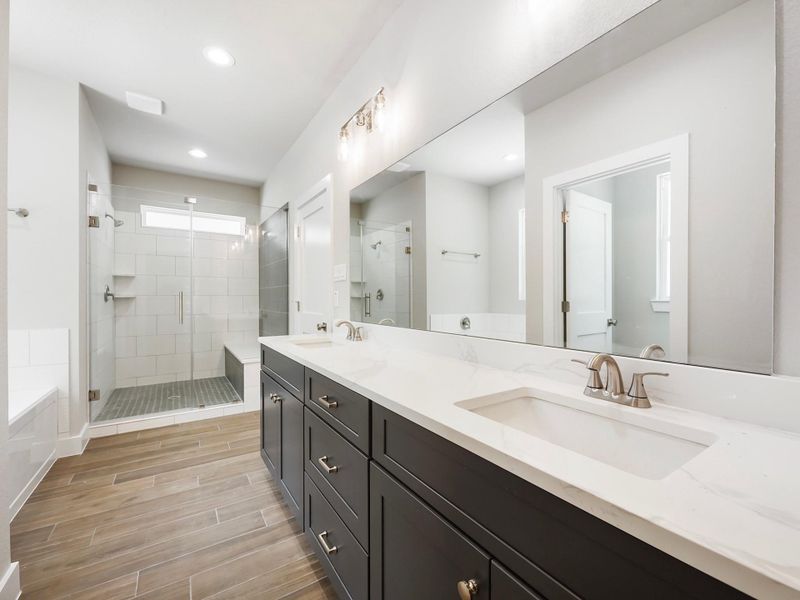 Bathroom is mix of navy blue and white cabinets