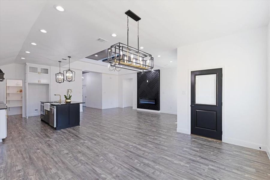 Kitchen featuring glass insert cabinets, dark countertops, open floor plan, and white cabinetry