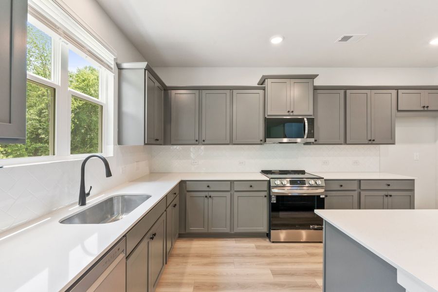 A kitchen with white cabinets.