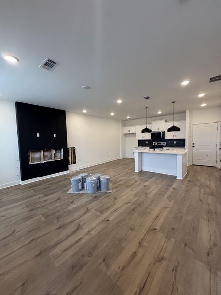 Unfurnished living room with dark wood-type flooring and recessed lighting