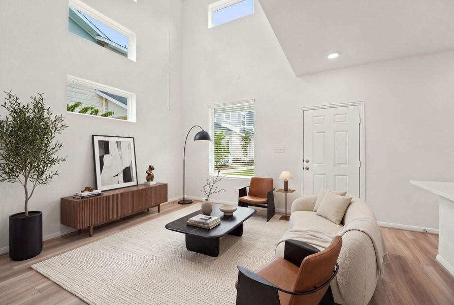 Double-height walls and wood floors define this airy living space with stacked transom windows.