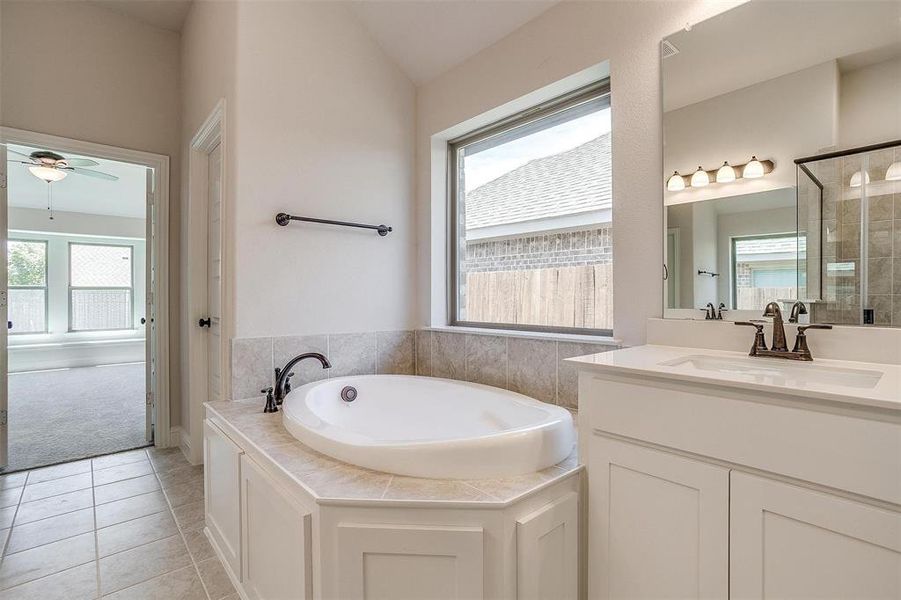 Bathroom featuring a wealth of natural light and a relaxing tiled tub