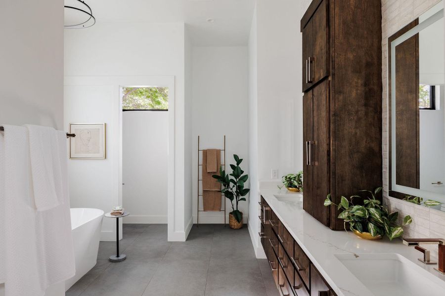 The primary bathroom features a custom dual-vanity with custom and refined stone surfaces throughout. The primary bathroom features a custom dual-vanity with custom and refined stone surfaces throughout.