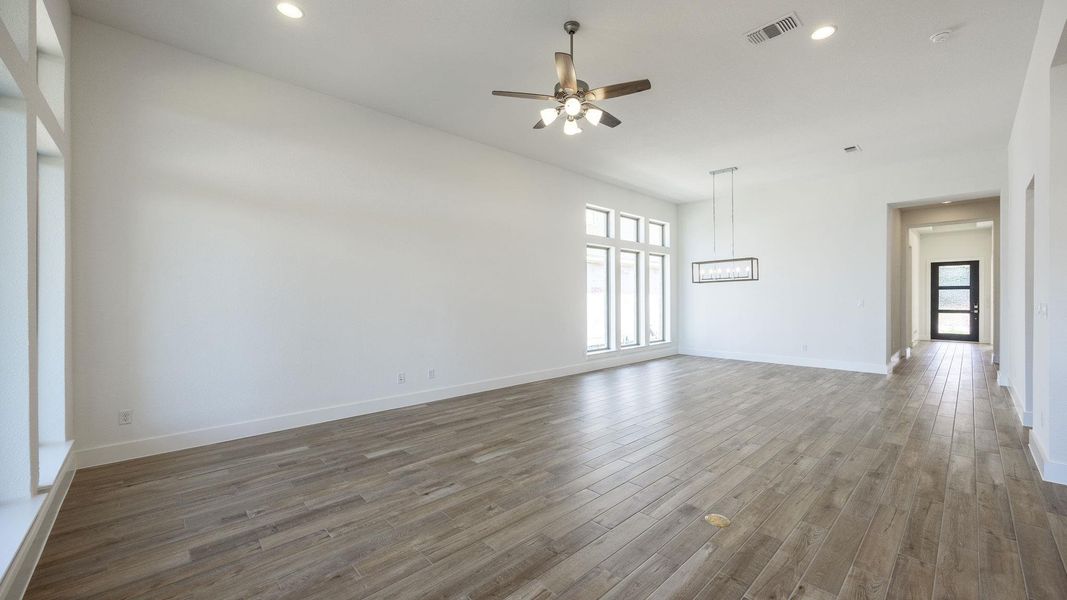 Spare room with ceiling fan, healthy amount of natural light, wood finished floors, baseboards, and recessed lighting Spare room with ceiling fan, healthy amount of natural light, wood finished floors, baseboards, and recessed lighting