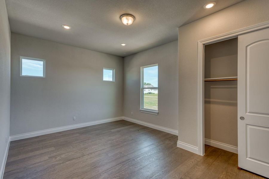 Unfurnished bedroom featuring wood finished floors, recessed lighting, a closet, and a textured ceiling