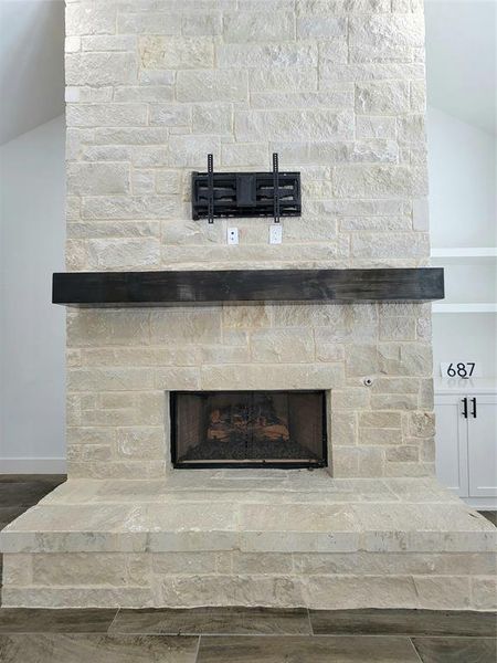 Room details with hardwood / wood-style flooring and a stone fireplace