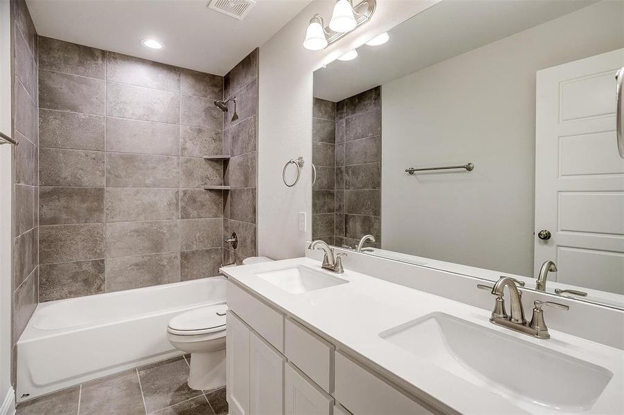 Bathroom with shower / tub combination, visible vents, a sink, and toilet