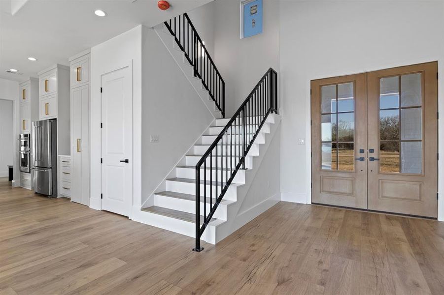 Entryway featuring french doors, light wood-style flooring, recessed lighting, and stairs Entryway featuring french doors, light wood-style flooring, recessed lighting, and stairs