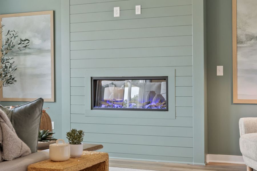 A room with a television and a table with a plant and a chair. A room with a television and a table with a plant and a chair.