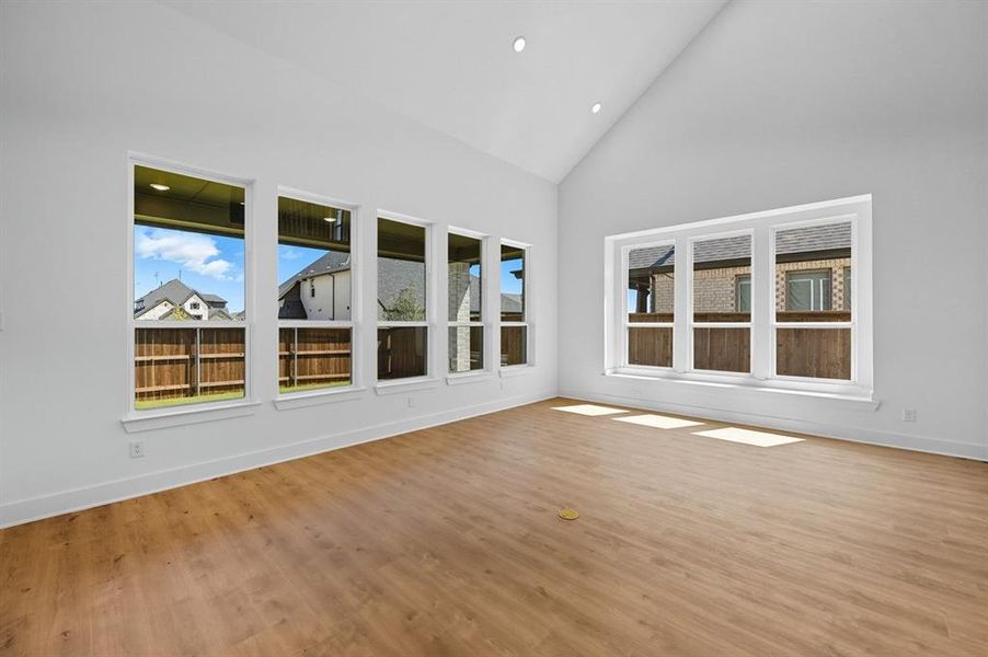 Unfurnished sunroom featuring high vaulted ceiling, recessed lighting, wood finished floors, and plenty of natural light Unfurnished sunroom featuring high vaulted ceiling, recessed lighting, wood finished floors, and plenty of natural light