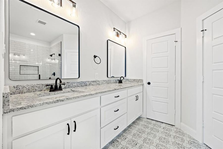 Bathroom with vanity and tiled shower