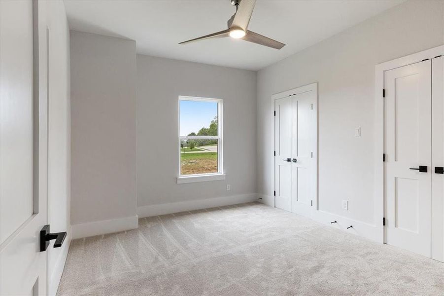 Carpeted empty room featuring ceiling fan