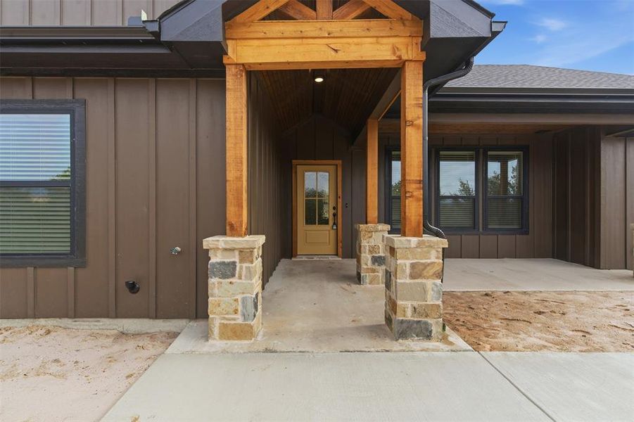 View of exterior entry featuring board and batten siding, a porch, and a shingled roof View of exterior entry featuring board and batten siding, a porch, and a shingled roof
