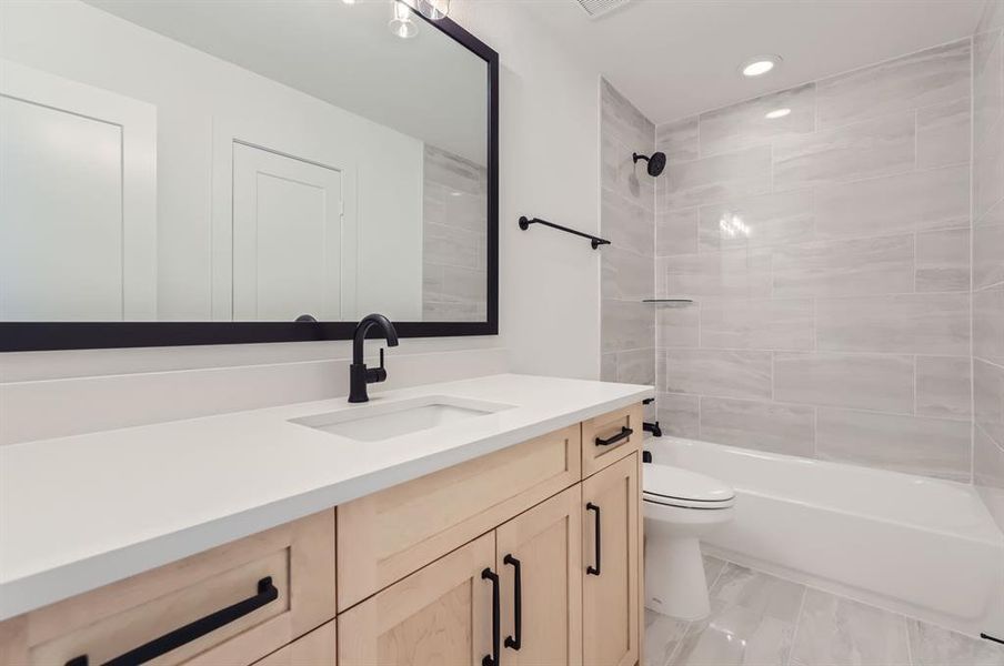 Full bathroom featuring vanity, toilet, and tiled shower / bath