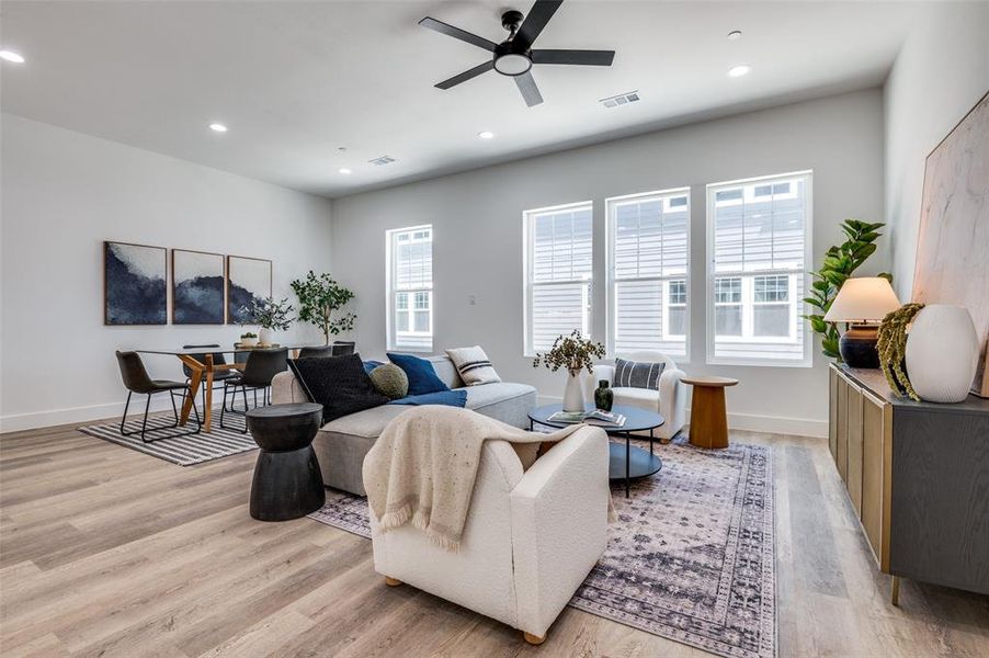 Living room featuring a ceiling fan, light wood-style flooring, and recessed lighting