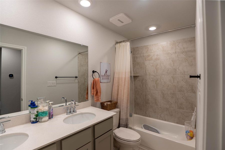 Full bath featuring shower / bath combination with curtain, double vanity, and recessed lighting Full bath featuring shower / bath combination with curtain, double vanity, and recessed lighting