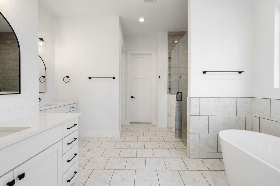 Full bath with a freestanding tub, vanity, a shower stall, tile walls, and recessed lighting