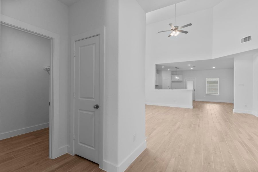 Spacious hallway view leading from the entry into the open living areas, with the utility room conveniently located on the left. Spacious hallway view leading from the entry into the open living areas, with the utility room conveniently located on the left.