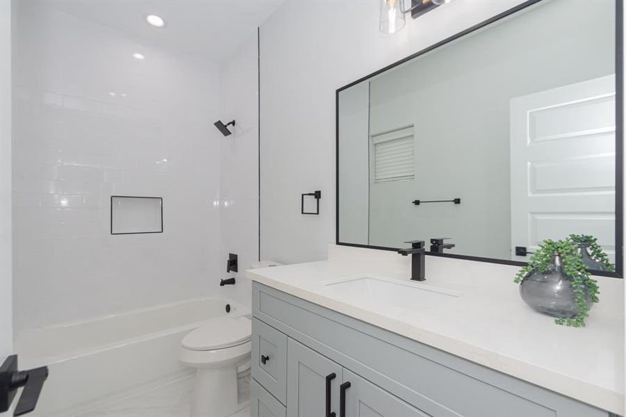 Each secondary bedroom features a full ensuite bathroom with quartz countertops, modern fixtures, and tile flooring.