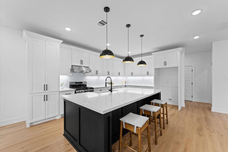 The crisp black and white contrast in the kitchen creates stylish elegance. Photo of similar layout.