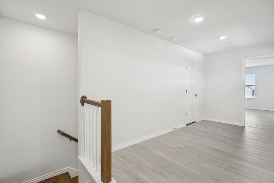 Empty room with dark wood finished floors and recessed lighting