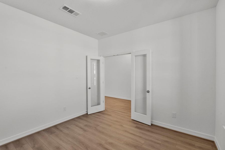 Spacious study featuring a double French door entry and a serene view of the front yard—ideal for work, reading, or quiet reflection.