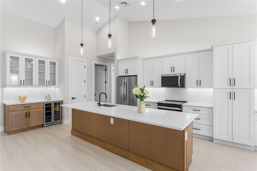 Elegant pendant lighting & recessed ceiling lights illuminate OPEN-CONCEPT SPACE, while GLASS-FRONT UPPER CABINETS add touch of ELEGANCE & DISPLAY STORAGE. Elegant pendant lighting & recessed ceiling lights illuminate OPEN-CONCEPT SPACE, while GLASS-FRONT UPPER CABINETS add touch of ELEGANCE & DISPLAY STORAGE.