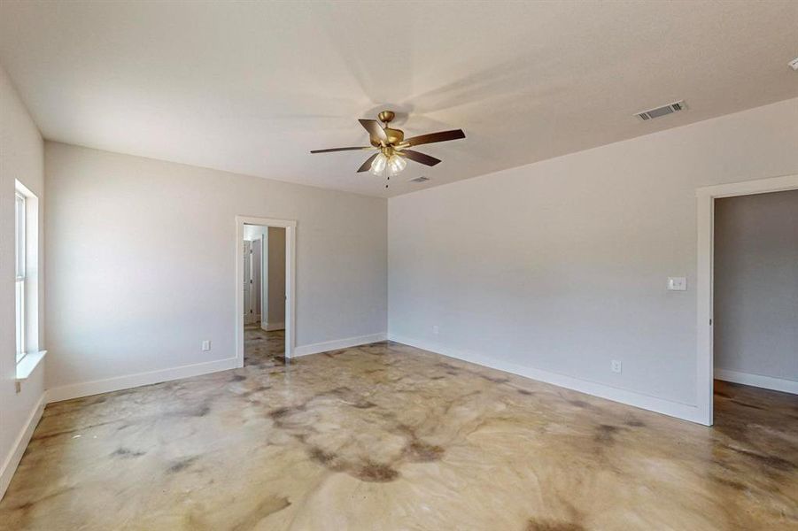 Unfurnished room with concrete flooring and ceiling fan