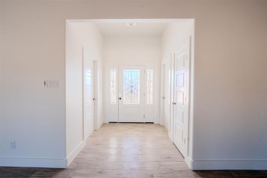 Foyer featuring baseboards and light wood-style flooring Foyer featuring baseboards and light wood-style flooring