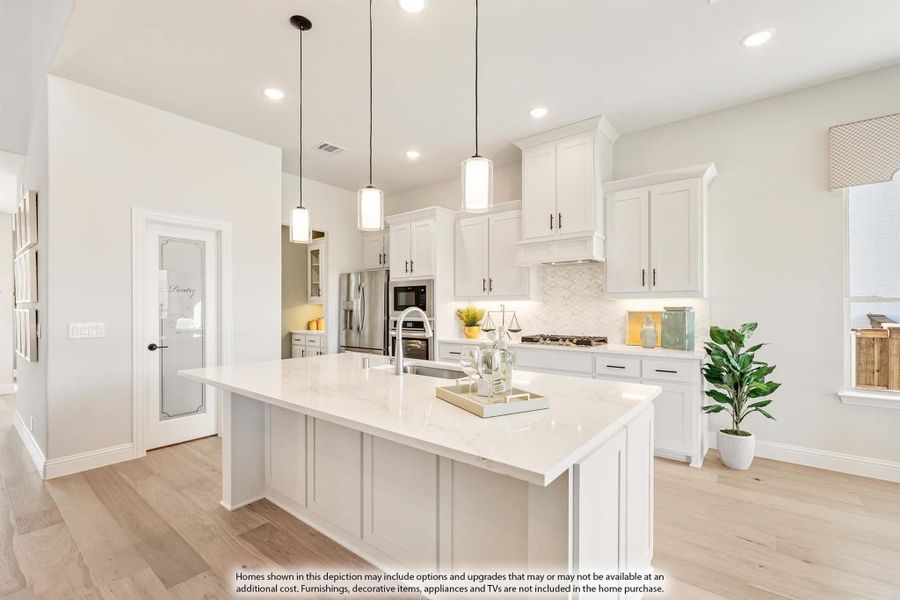 White kitchen with large center island, pendant lights, stainless appliances, and light hardwood floors