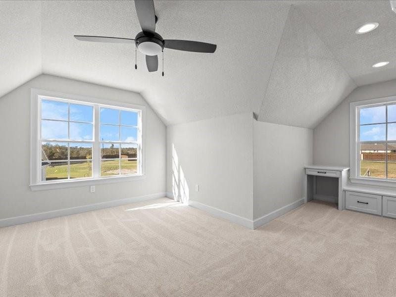 Bonus room with vaulted ceiling, light carpet, and a textured ceiling Bonus room with vaulted ceiling, light carpet, and a textured ceiling
