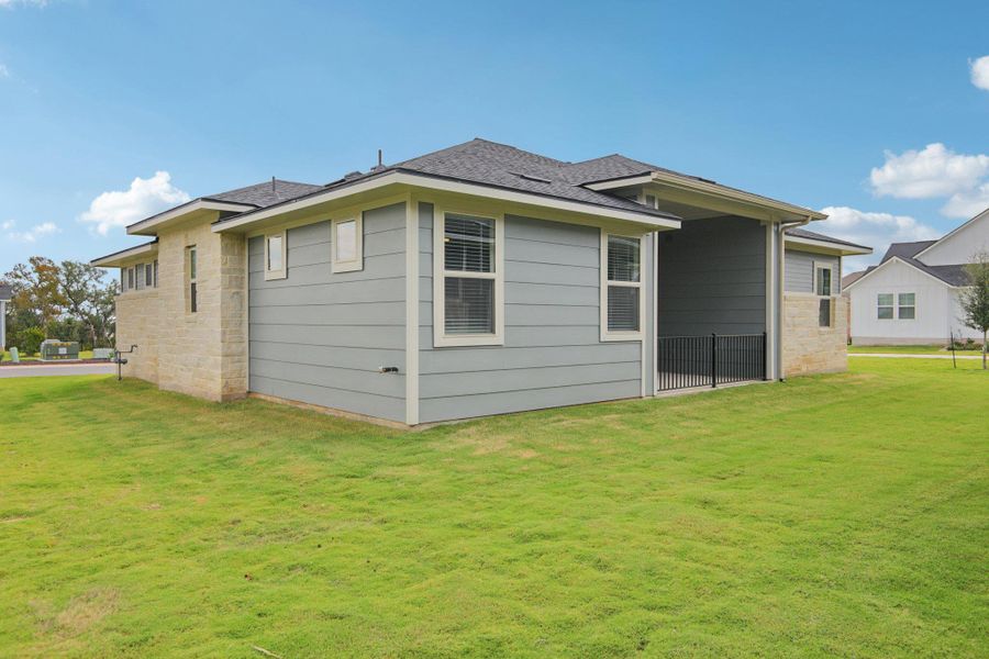 Rear view of house featuring a lawn and a shingled roof