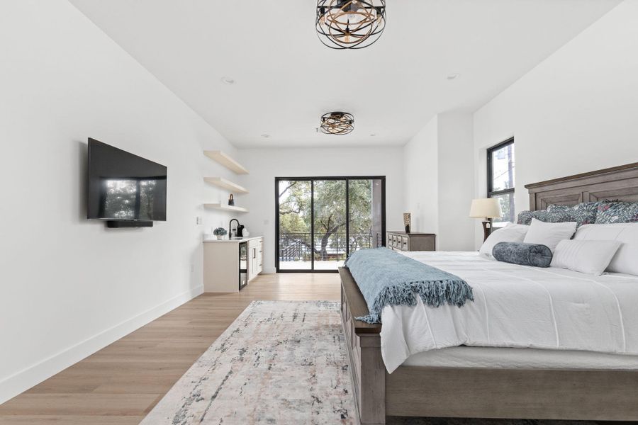 Bedroom with multiple windows, access to exterior, and light wood-style floors