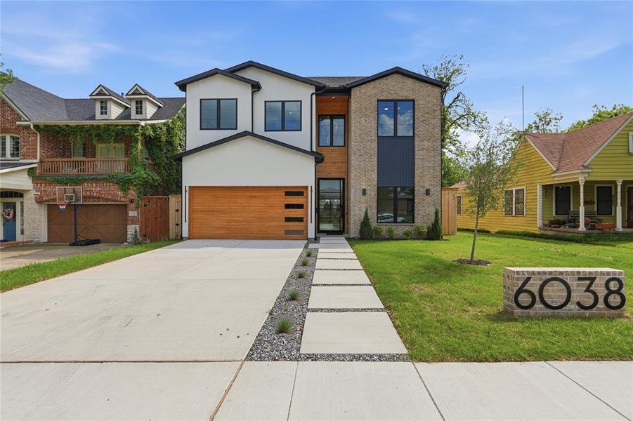 Contemporary facade featuring a mix of light-toned stucco, dark brick, and vertical wood-look siding Contemporary facade featuring a mix of light-toned stucco, dark brick, and vertical wood-look siding
