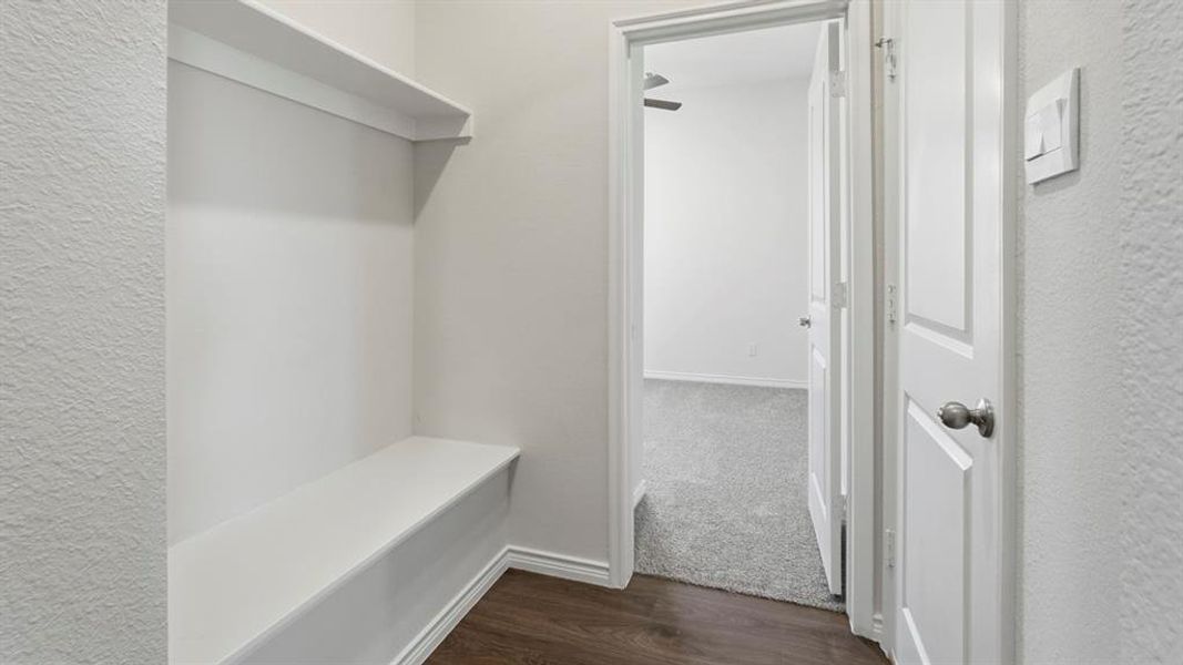 Mudroom featuring dark wood-style flooring and a textured wall