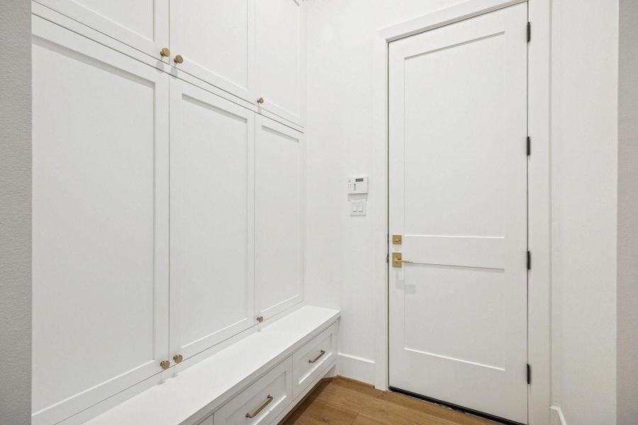 Thoughtfully designed mud room featuring custom built in cabinetry, soft close storage, and elegant brass hardware that blends function with refined style.