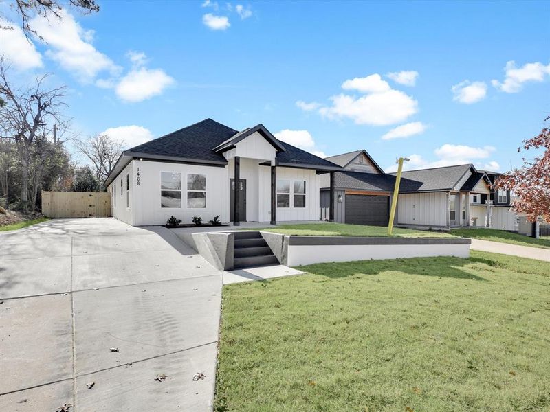 View of front of property featuring a garage and a front lawn