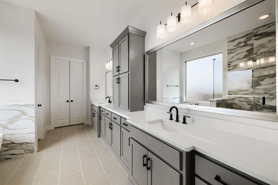 Contemporary bathroom featuring a double vanity with grey cabinetry, white countertops, and black fixtures Contemporary bathroom featuring a double vanity with grey cabinetry, white countertops, and black fixtures