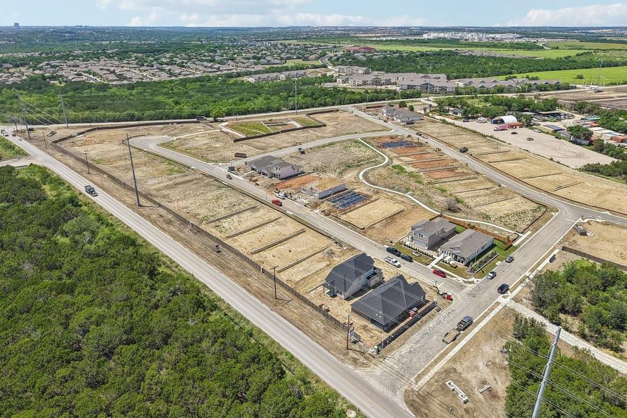A high-elevation perspective showcases the developing residential neighborhood and surrounding green space.
